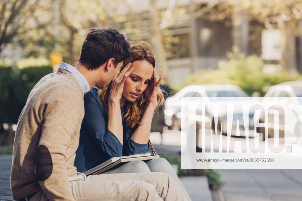 Couple sitting outdoors with woman holding head in hands model released Symbolfoto CHAF000941