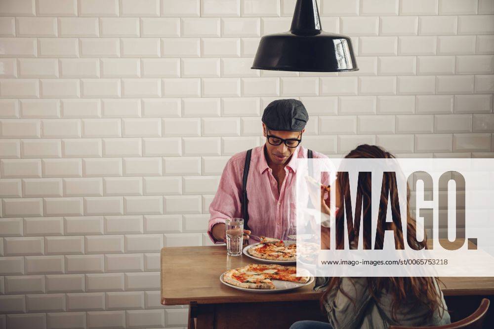 Young couple eating pizza in restaurant model released Symbolfoto property released CHAF001284