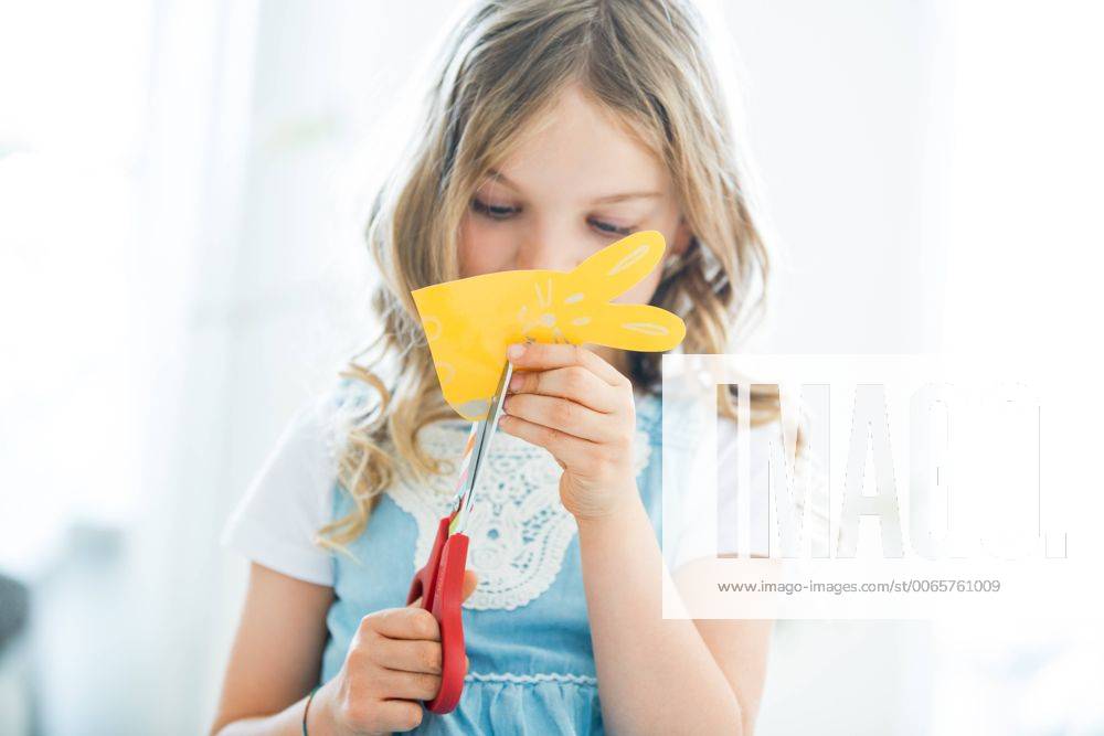 Little girl cutting out paper Easter bunnies model released Symbolfoto property released WESTF021544