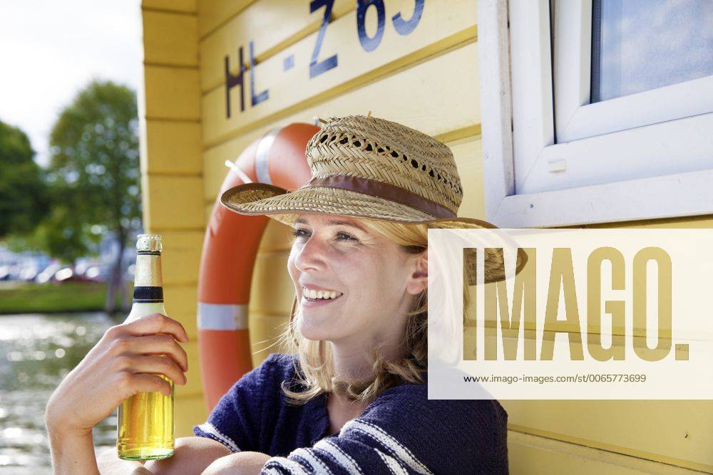 Smiling woman on a house boat with beer bottle model released Symbolfoto property released FMKF001938