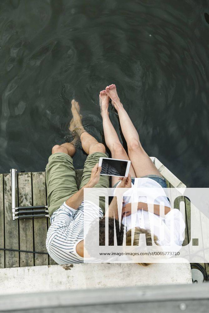 Couple sharing digital tablet at the water model released Symbolfoto property released FMKF001943