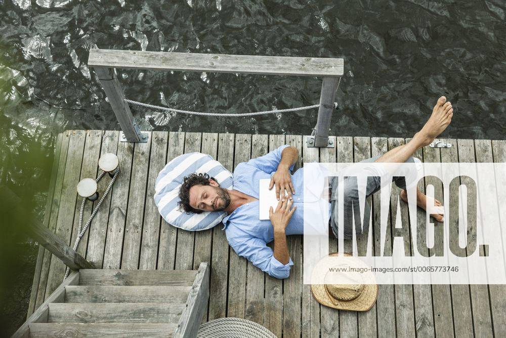 Man lying on platform at the waterside model released Symbolfoto property released FMKF001970