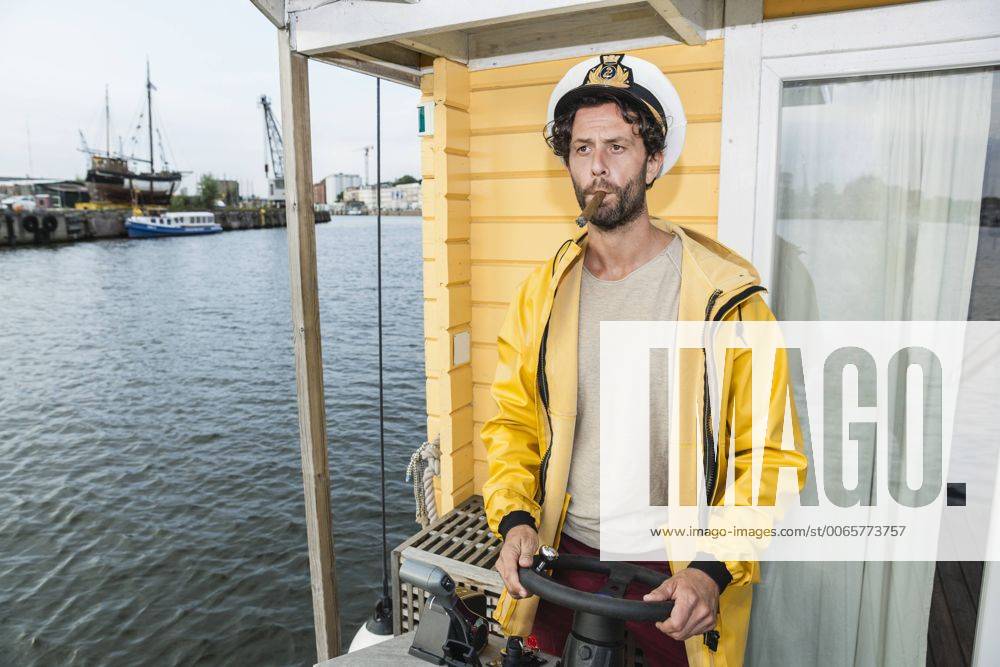 Captain with cigar steering hpuse boat model released Symbolfoto property released FMKF001981