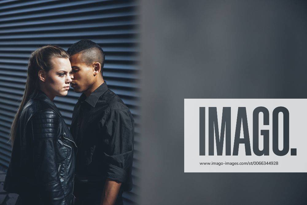 Black dressed young couple standing in front of black facade model released Symbolfoto CHAF001383