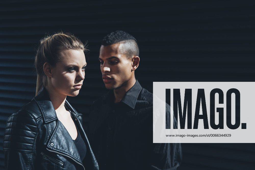 Black dressed young couple standing in front of black facade model released Symbolfoto CHAF001384