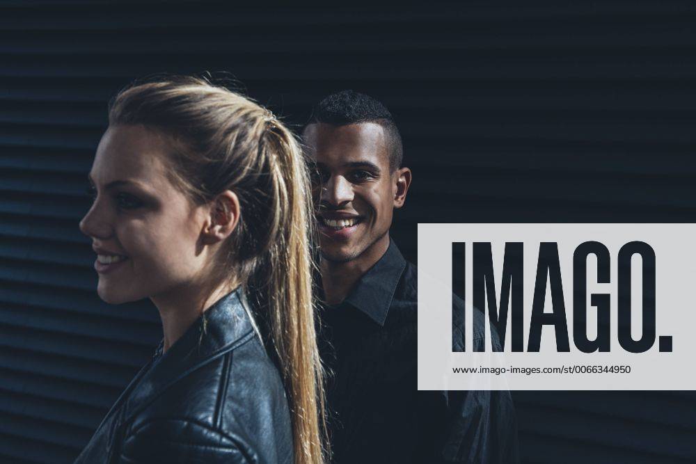 Black dressed young couple standing in front of black facade model released Symbolfoto CHAF001386