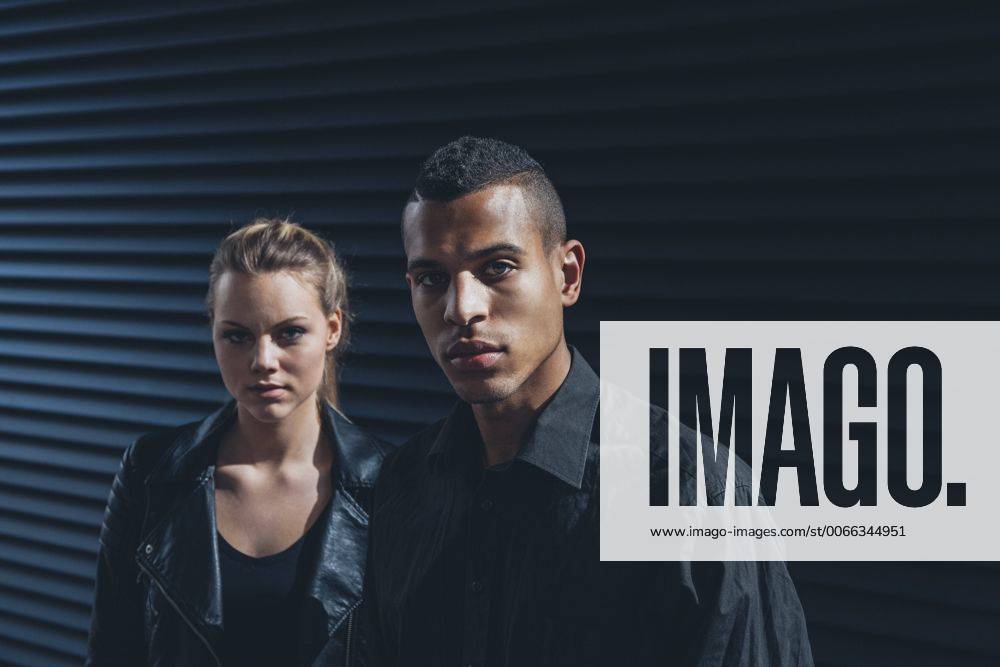 Black dressed young couple standing in front of black facade model released Symbolfoto CHAF001387