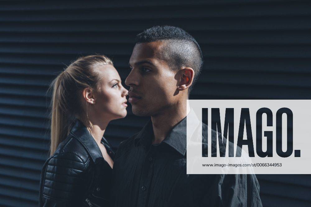 Black dressed young couple standing in front of black facade model released Symbolfoto CHAF001388