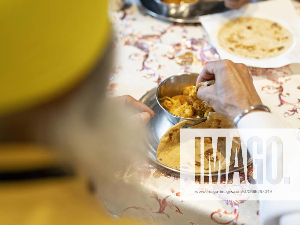 IMAGO Creative, Food, Brot, Naan Man eating traditional Indian food at home model released