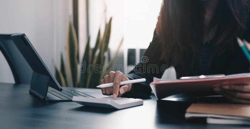 Close up Business woman using calculator and laptop for do math finance on wooden desk in office and business working background,, Close up Business woman using calculator and laptop for do math finance on wooden desk in office and business working background, tax, accounting, statistics and analytic research concept.