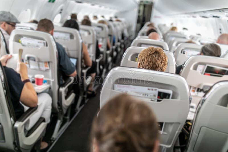 Interior of commercial airplane with passengers, Interior of commercial airplane with passengers in their seats during flight.