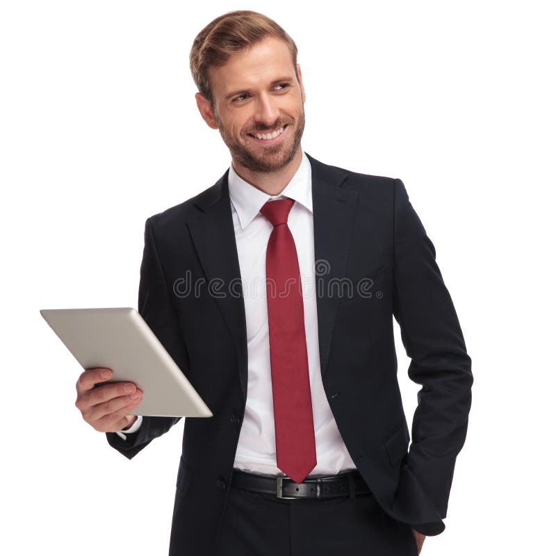 Portrait of smiling businessman holding pad and looking to side, Portrait of smiling businessman holding pad and looking to e while standing on white background with hands in pockets model released