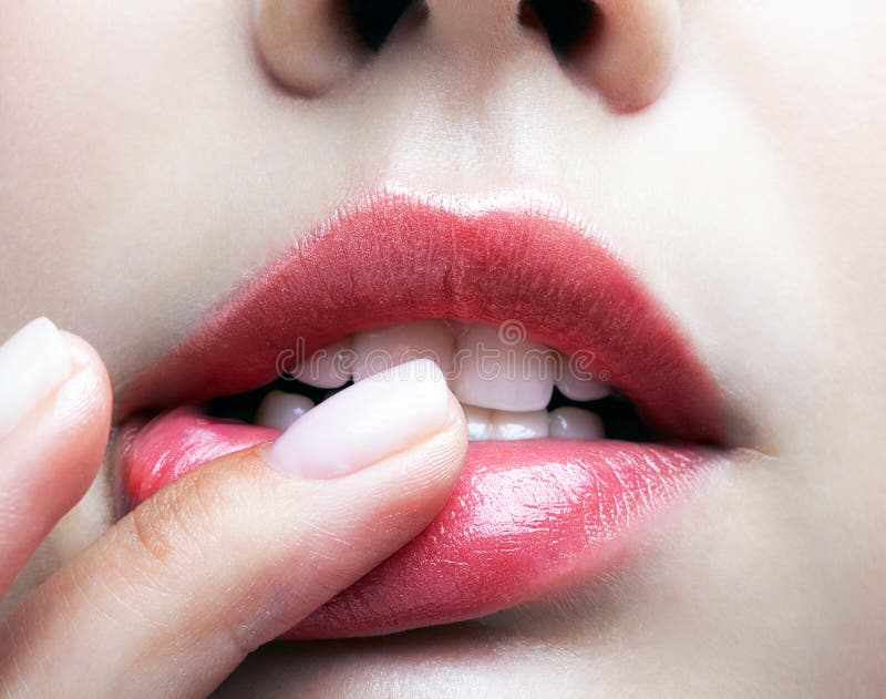 Closeup macro portrait of female part of face. Human woman lips, Closeup macro portrait of female part of face. Human woman lips with day beauty makeup. Girl with perfect plump lips shape an finger on lips. model released
