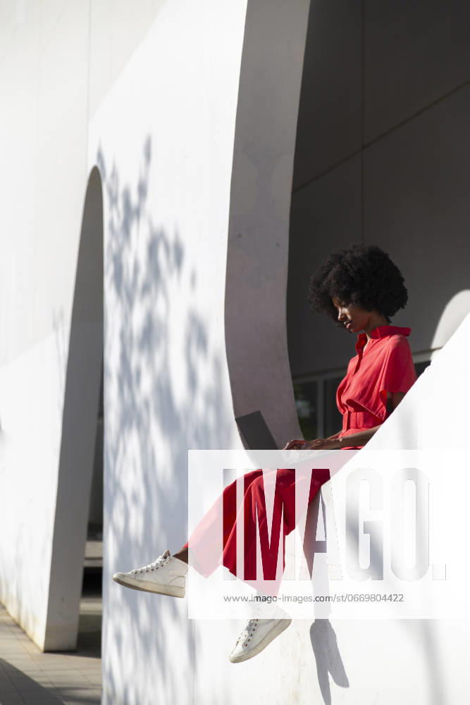 Freelancer using laptop and sitting on wall of modern building model released, Symbolfoto, PCLF01100