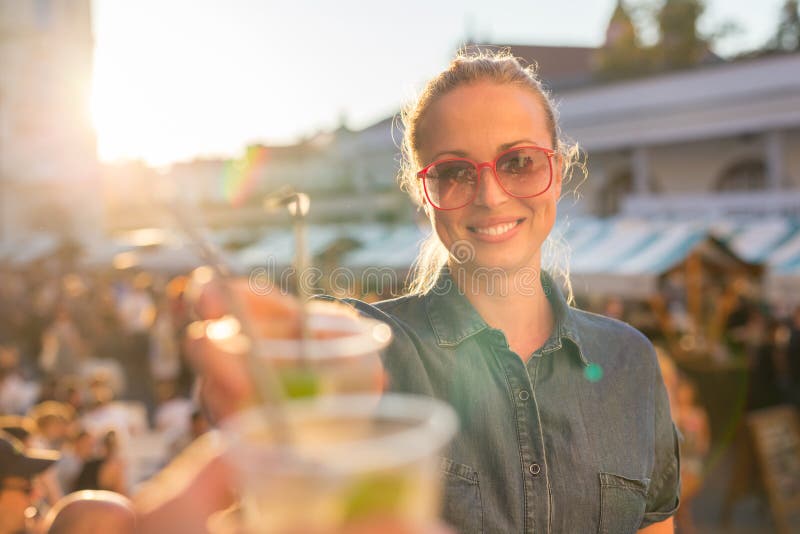Beautiful young girl toasting on outdoor urban event., Beautiful young girl toasting outdoors on Open kitchen street food festival in Ljubljana, Slovenia. Popular summer urban tourist event in capital. model released