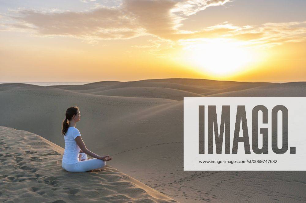 Woman practising yoga on sand dunes model released Symbolfoto DIGF000026
