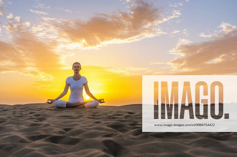 Woman practising yoga on sand dunes model released Symbolfoto DIGF000030