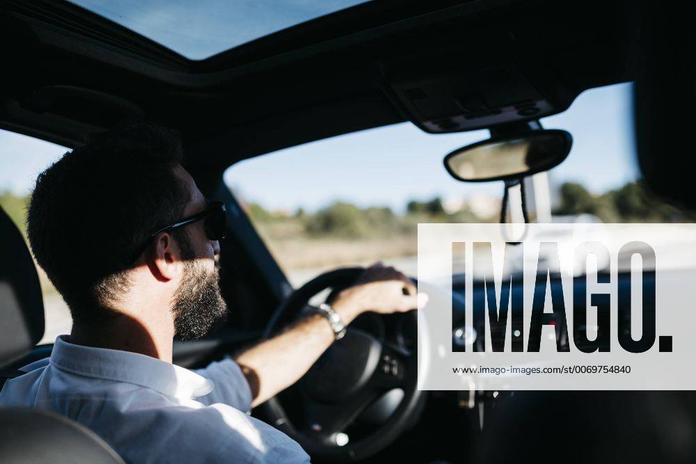 Young man driving a car model released Symbolfoto JRFF000312