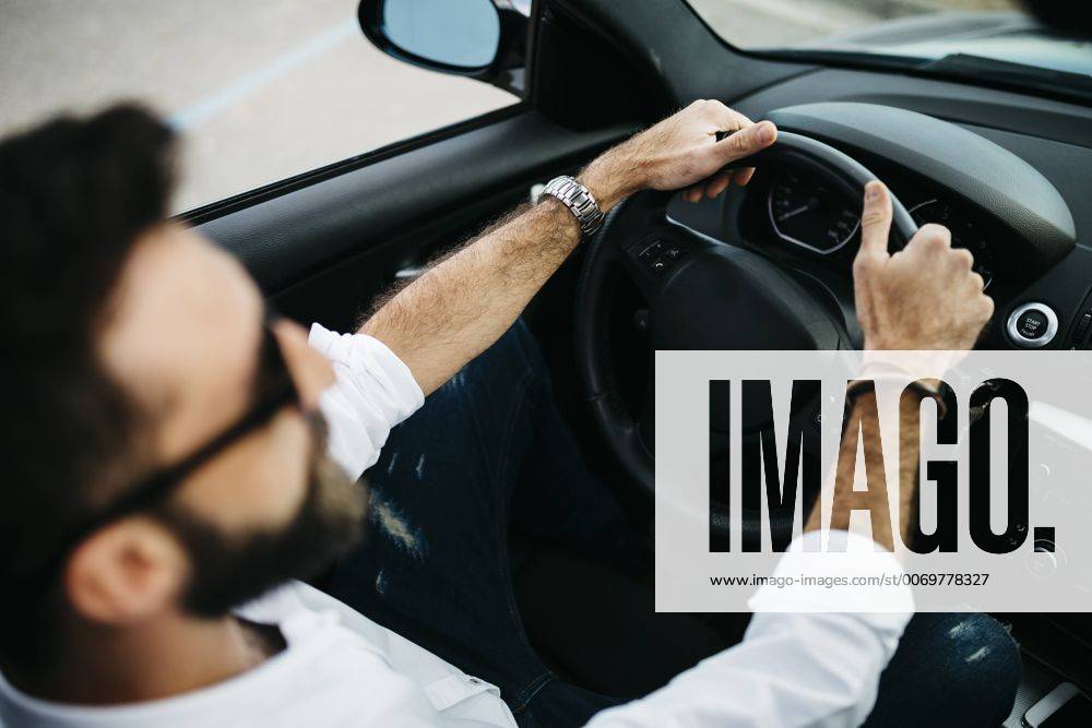Young man driving a car model released Symbolfoto JRFF000323