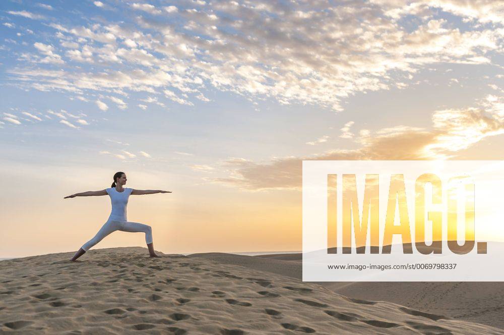 Woman practising yoga on sand dunes model released Symbolfoto DIGF000025