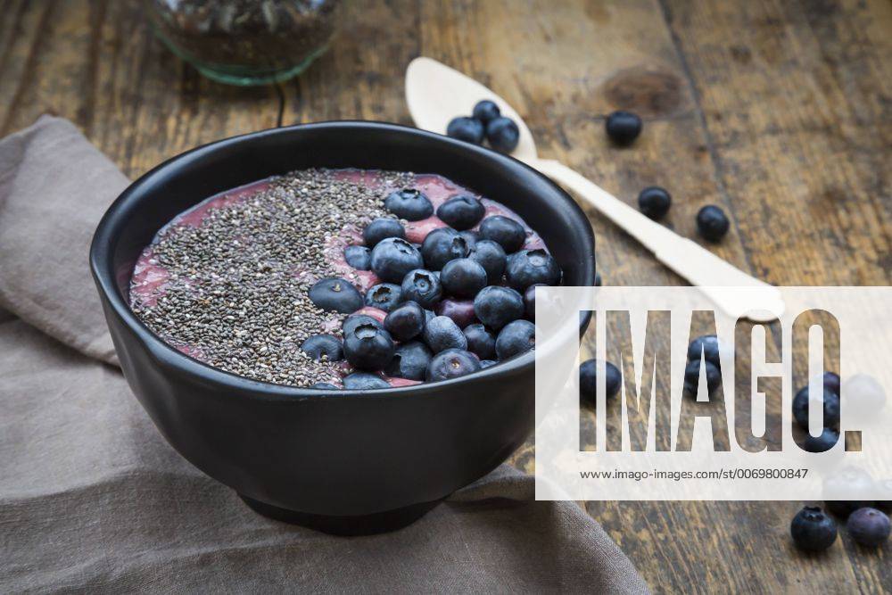 Blueberry smoothie with chia seeds in bowl, fresh blueberries LVF004503