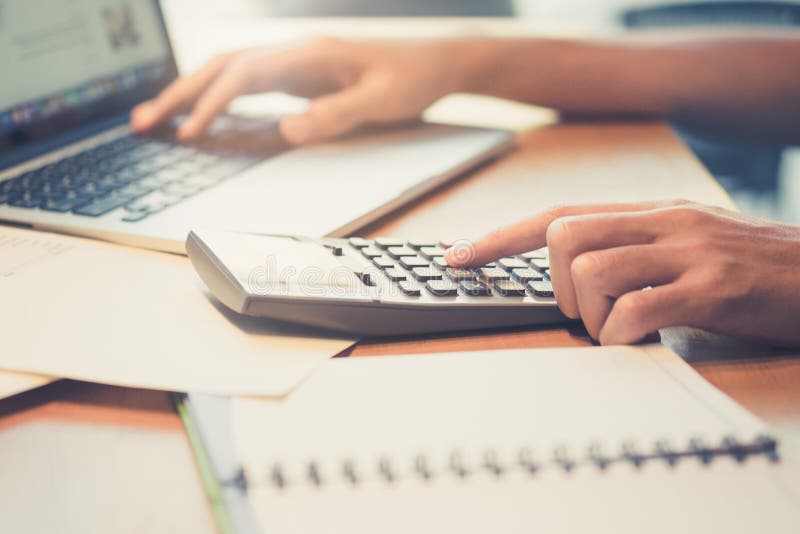 Close up Business man using calculator and laptop computer for c, Close up Business man using calculator and laptop computer for calculating with finance paper, tax, accounting, Accountant concept.