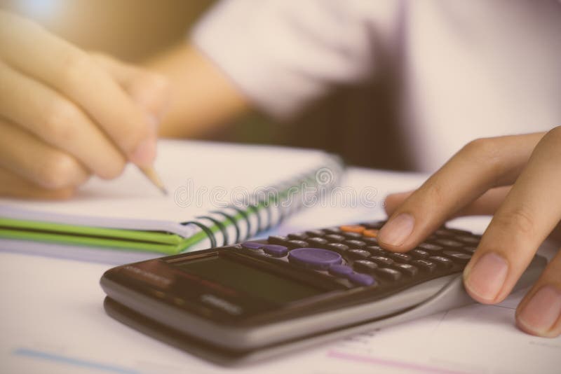 Close up Business man using calculator and writing on notebook f, Close up Business man using calculator and writing on notebook for calculating with finance paper, tax, accounting.