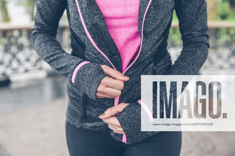 Woman closing zipper of sportive jacket model released Symbolfoto DAPF000038