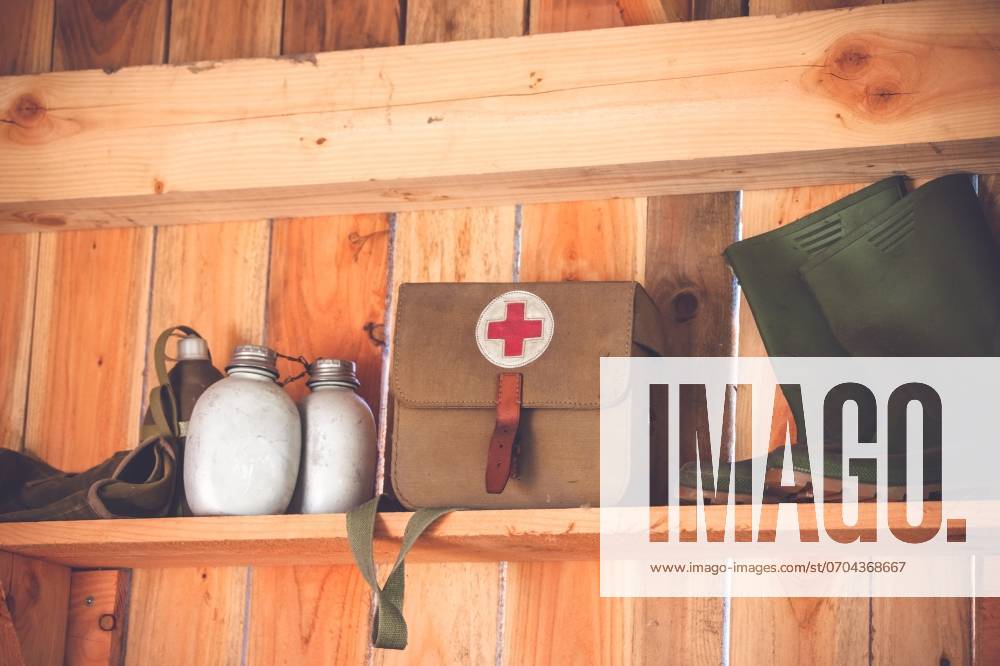 Retro medic equipment on an old wooden shelfe with boots and water bottles ,model released, Symbolfoto