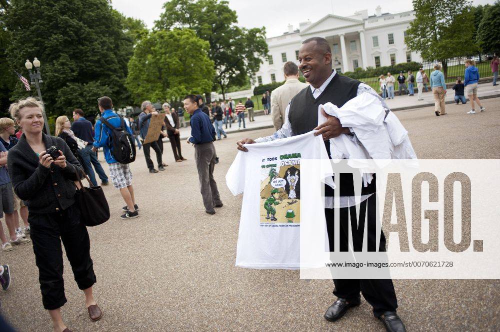 Washington, District of Columbia, U.S. - A man selling freshly made t-shirts was among the people gathered in front of the White House on Moday to celebrate the death of Osama. President Obama addressed the nation Sunday night saying a team of U.S. personnel attacked a compound in Pakistan s Abbottabad Valley. During a firefight, the U.S. team killed bin Laden, and took custody of his body in what Obama called the most significant achievement to date in our nation s effort to defeat al-Qaeda. - ZUMAmv2_