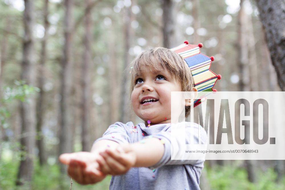 Portrait of smiling little boy wearing paper crown catching confetti model released Symbolfoto VABF000360