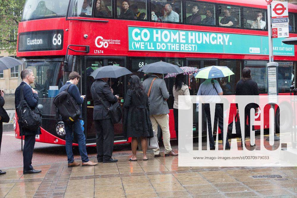 London, London, UK - LONDON, UK. Commuters are caught in heavy rain showers as they wait for busses to make their way to work from Waterloo station in central London this morning. London UK - ZUMAl94_