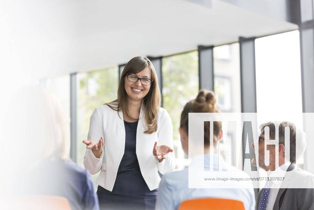 Smiling businesswoman planning strategy with colleagues during meeting at office ,model released, Symbolfoto