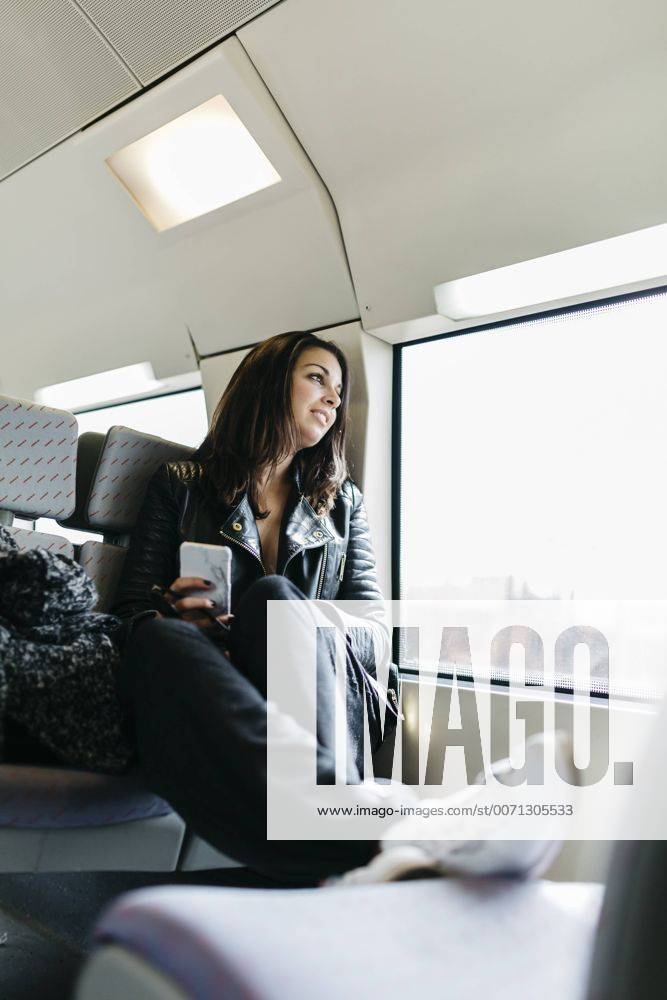 Young woman on train looking out of window model released Symbolfoto JRFF000634