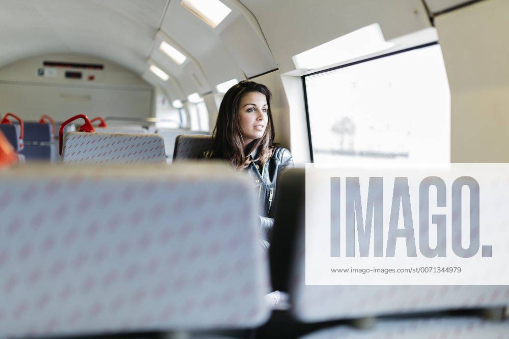 Young woman on train looking out of window model released Symbolfoto JRFF000631