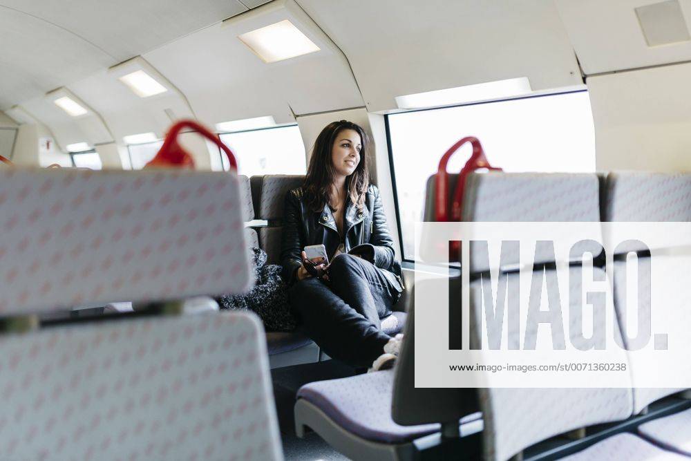 Young woman on train looking out of window model released Symbolfoto JRFF000632