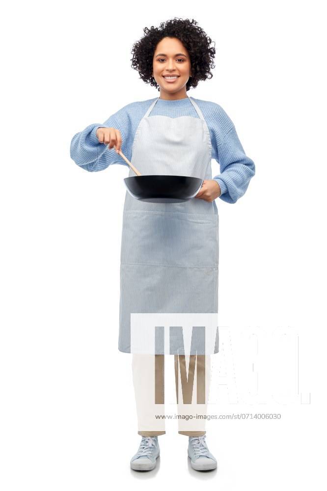 Culinary and people concept - happy smiling woman in apron with frying pan and spoon cooking food over white background. happy woman in apron cooking food in frying pan ,model released, Symbolfoto