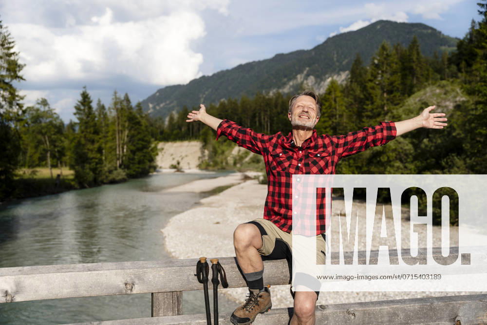 Cheerful man enjoying a hike in the mountains on a sunny day near a river in Germany. model released, Symbolfoto, DIGF21470
