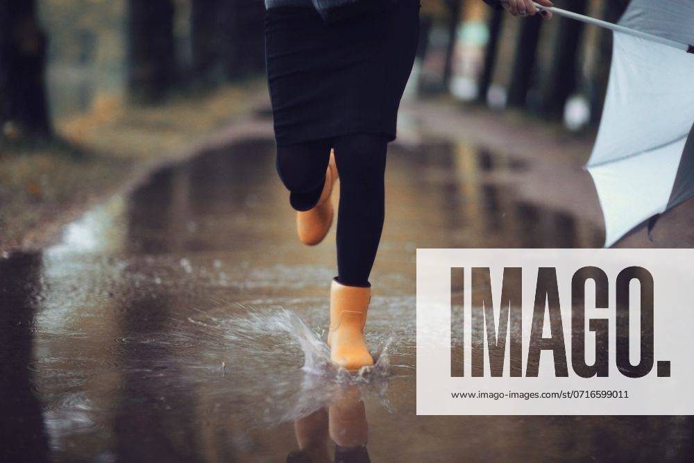 Feet in rubber boots rain puddle city ,model released, Symbolfoto