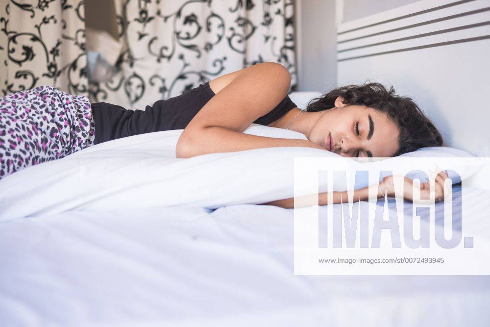 Teenage girl sleeping in bed model released Symbolfoto property released SIPF000596