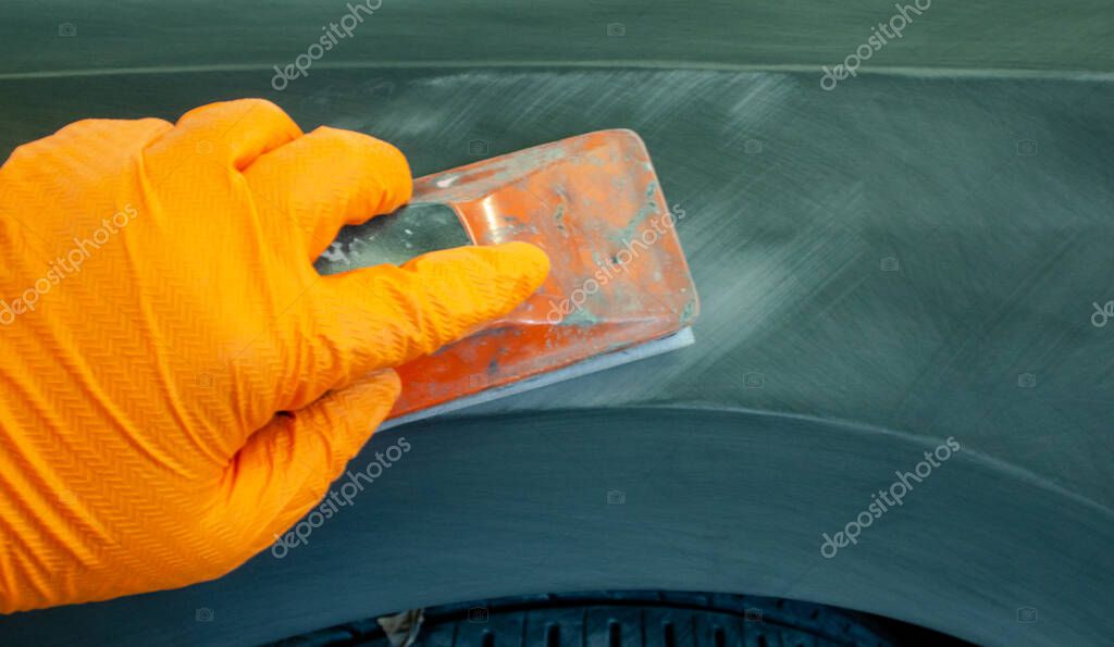 The process of treating the soil with an abrasive material manually. manual repair of car paintwork.