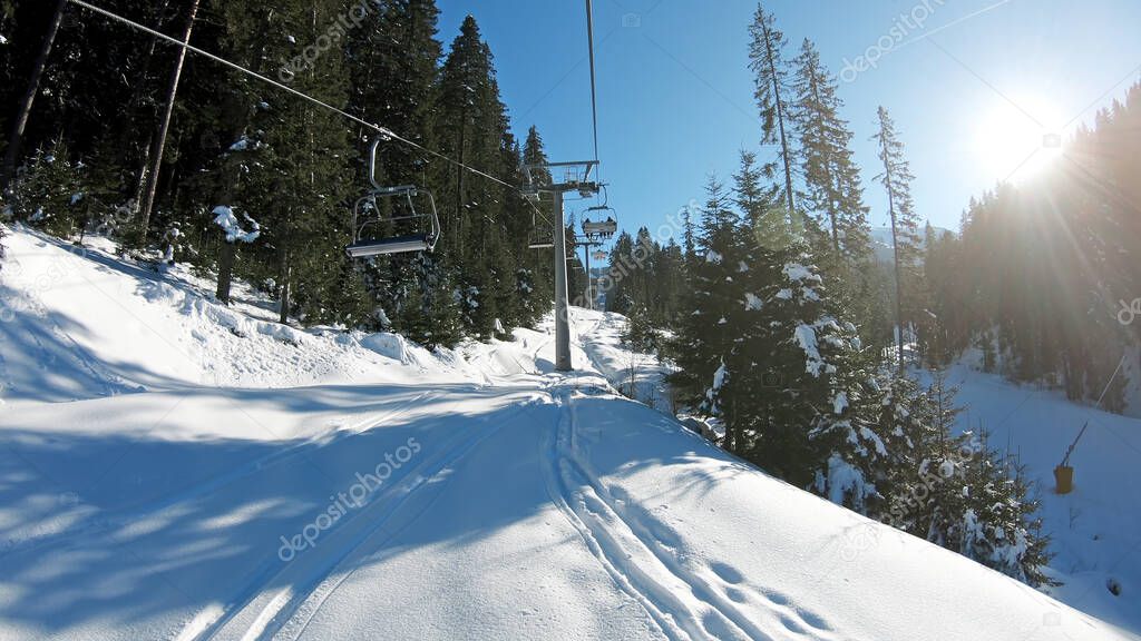 Mountains landscape pov with ski slopes and ski lifts on sunny day at mountain summit Todorka in Bansko world cup ski resort in Bulgaria