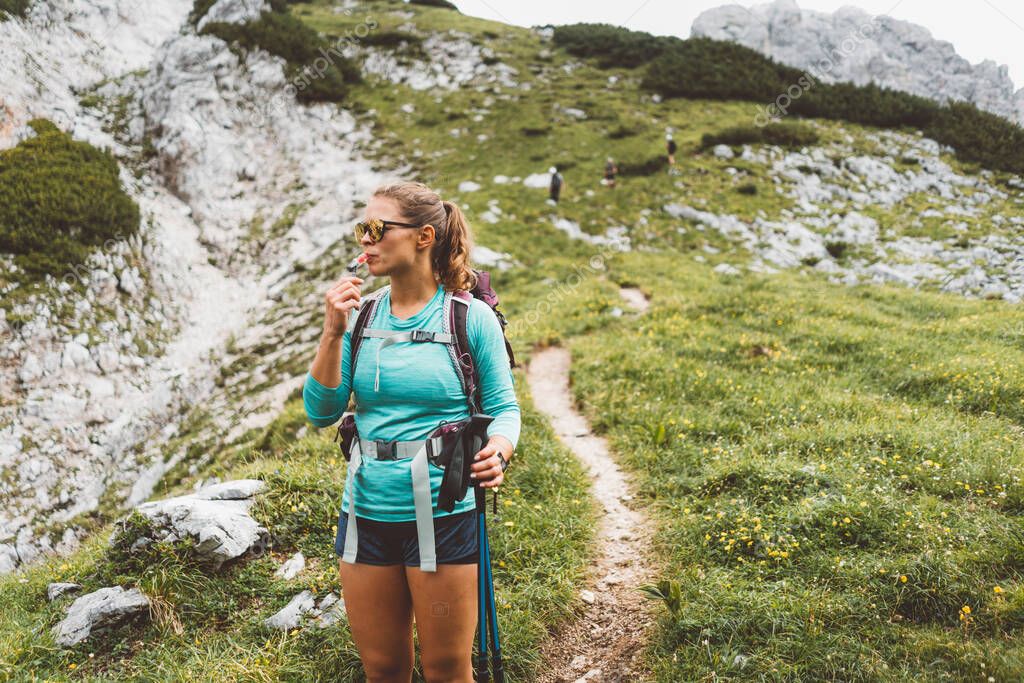 Caucasian woman hiking with Backpack on the Beautiful trail in European Alps early in the morning. Travel and Adventure Concept. High quality photo