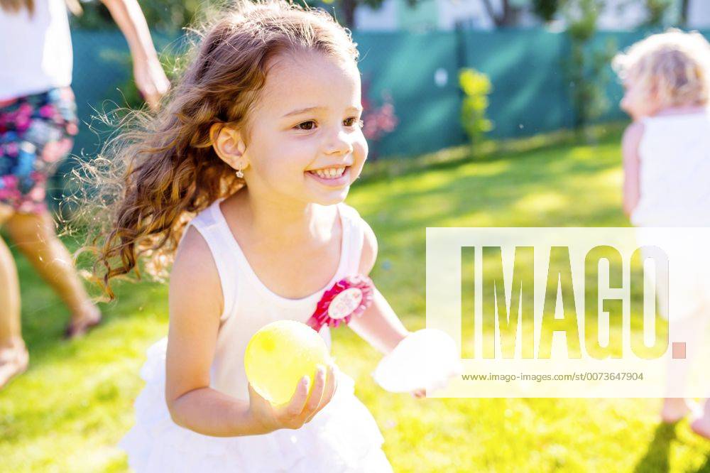 Little girl having fun with water bombs in the garden model released Symbolfoto HAPF000765
