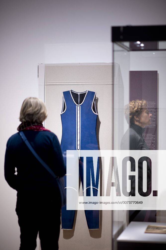 The British View Germany - Memories of a Nation, Exhibition Gropius-Bau DEU, Deutschland, Germany, Berlin, 07.10.2016 Besucher neben dem Surfanzug von 1987, Symbol fuer die Flucht ueber Wasser aus der DDR, in der Ausstellung Der Britische Blick Deutschland - Erinnerungen einer Nation, The British View German - Memories of a Nation, im Martin-Gropius-Bau in Berlin. Die Ausstellung eroeffnet am 08. Oktober und geht bis 09. Januar und praesentiert ca 200 Objekte welche einen Bezug zu den letzten 600 Jahre Geschichte in Deutschland haben. Sie zeigt Spuren deutscher Identitaet aus britischer Perspektive. Visitor next to a Wetsuit from 1987, a symbol for the escape out of the former GDR, on display during his exhibition Der Britische Blick Deutschland - Erinnerungen einer Nation, The British View German - Memories of a Nation, at the Martin Gropius Bau in Berlin, Germany. The exhibition opens