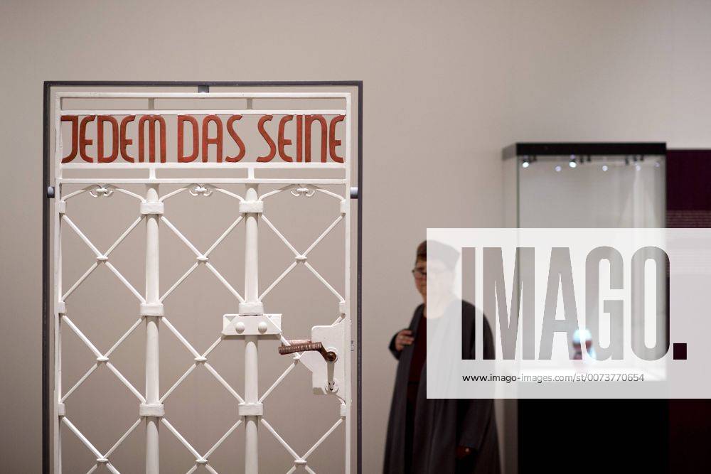 The British View Germany - Memories of a Nation, Exhibition Gropius-Bau DEU, Deutschland, Germany, Berlin, 07.10.2016 Besucher betrachtet das Lagertor des Konzentrationslager KZ Buchenwald mit der Inschrift Jedem das Seine in der Ausstellung Der Britische Blick Deutschland - Erinnerungen einer Nation, The British View German - Memories of a Nation, im Martin-Gropius-Bau in Berlin. Die Ausstellung eroeffnet am 08. Oktober und geht bis 09. Januar und praesentiert ca 200 Objekte welche einen Bezug zu den letzten 600 Jahre Geschichte in Deutschland haben. Sie zeigt Spuren deutscher Identitaet aus britischer Perspektive. Visitor next to a gate from the former Buchenwald concentration camp with the words Jedem das Seine, To Each What He Deserves, on display during his exhibition Der Britische Blick Deutschland - Erinnerungen einer Nation, The British View German - Memories of a Nation, at the
