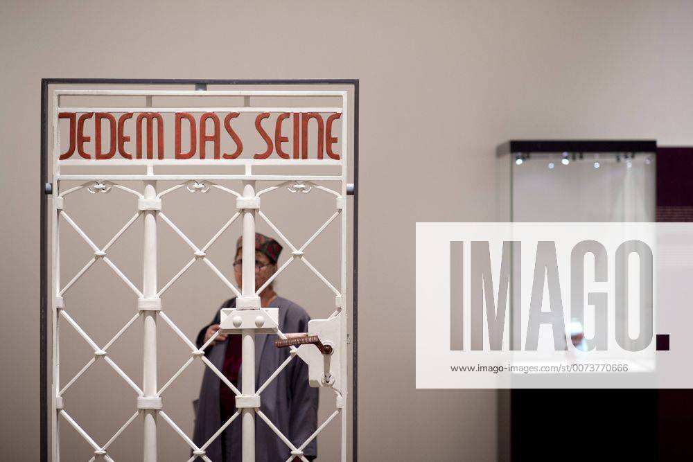 The British View Germany - Memories of a Nation, Exhibition Gropius-Bau DEU, Deutschland, Germany, Berlin, 07.10.2016 Besucher betrachtet das Lagertor des Konzentrationslager KZ Buchenwald mit der Inschrift Jedem das Seine in der Ausstellung Der Britische Blick Deutschland - Erinnerungen einer Nation, The British View German - Memories of a Nation, im Martin-Gropius-Bau in Berlin. Die Ausstellung eroeffnet am 08. Oktober und geht bis 09. Januar und praesentiert ca 200 Objekte welche einen Bezug zu den letzten 600 Jahre Geschichte in Deutschland haben. Sie zeigt Spuren deutscher Identitaet aus britischer Perspektive. Visitor next to a gate from the former Buchenwald concentration camp with the words Jedem das Seine, To Each What He Deserves, on display during his exhibition Der Britische Blick Deutschland - Erinnerungen einer Nation, The British View German - Memories of a Nation, at the