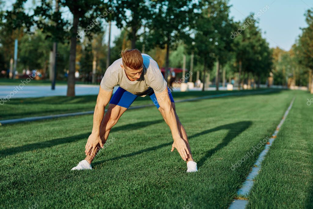 Sporty man in the park on the lawn exercise lifestyle. High quality photo