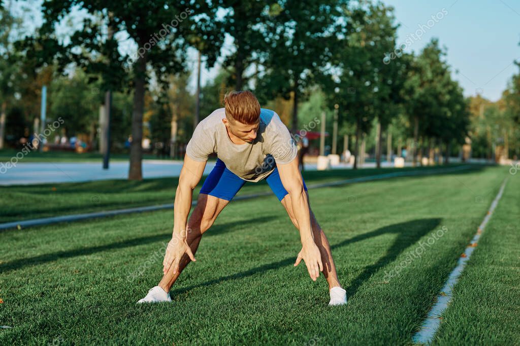 Sporty man in the park on the lawn exercise lifestyle. High quality photo