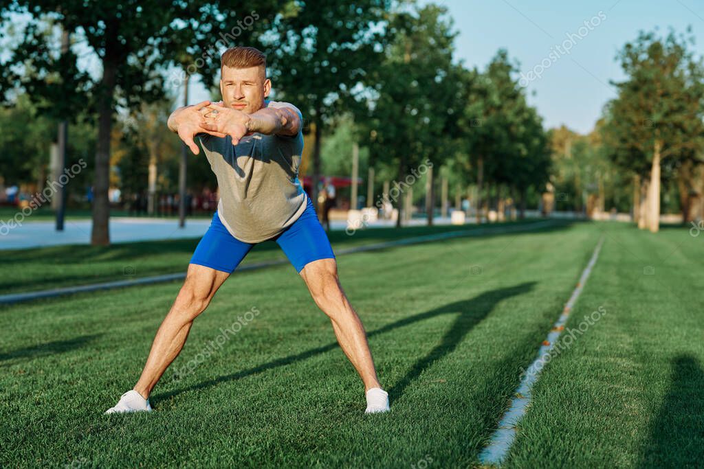 Sporty man in the park on the lawn exercise lifestyle. High quality photo